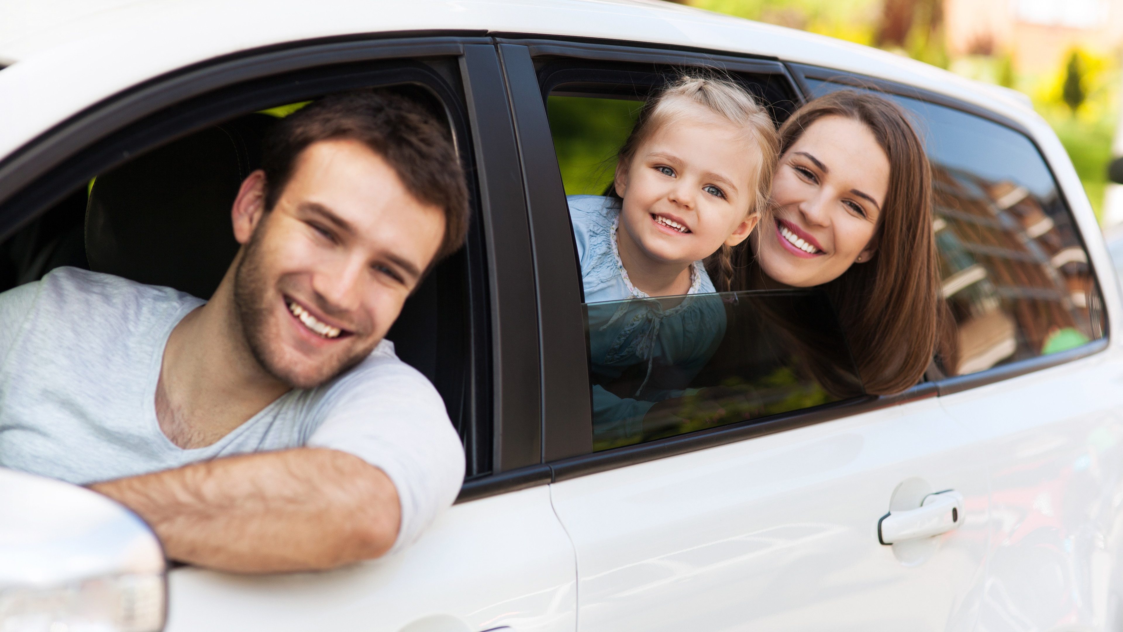 Family sitting in the car looking out windows 